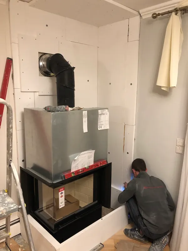 Monteur bei der Montage einer Kaminverkleidung