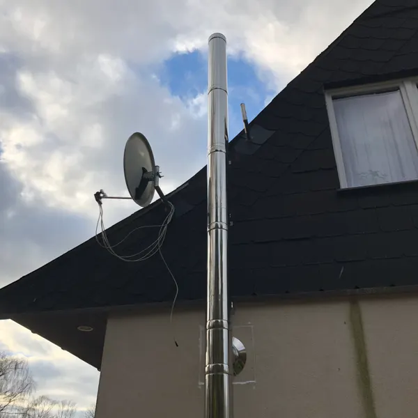 Außenliegendes Edelstahlschornsteinsystem unterhalb eines Daches