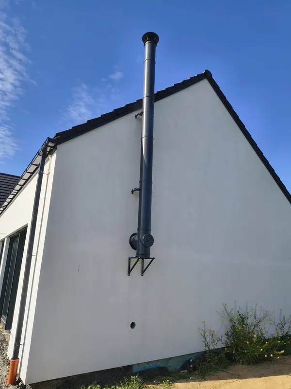 Edelstahlschornstein an der Giebelfassade eines Wohnhauses