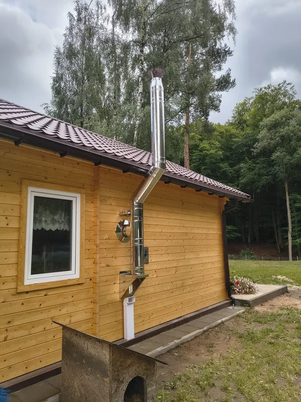 Edelstahlschornstein an einem eingeschossigen Holzhaus